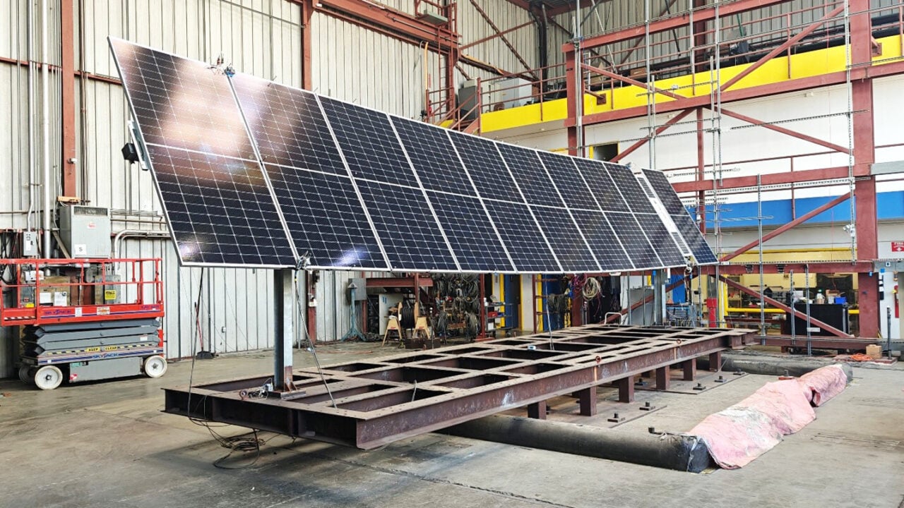 A solar tracker field with mountains in the background, illustrating installation in a seismic-prone region.