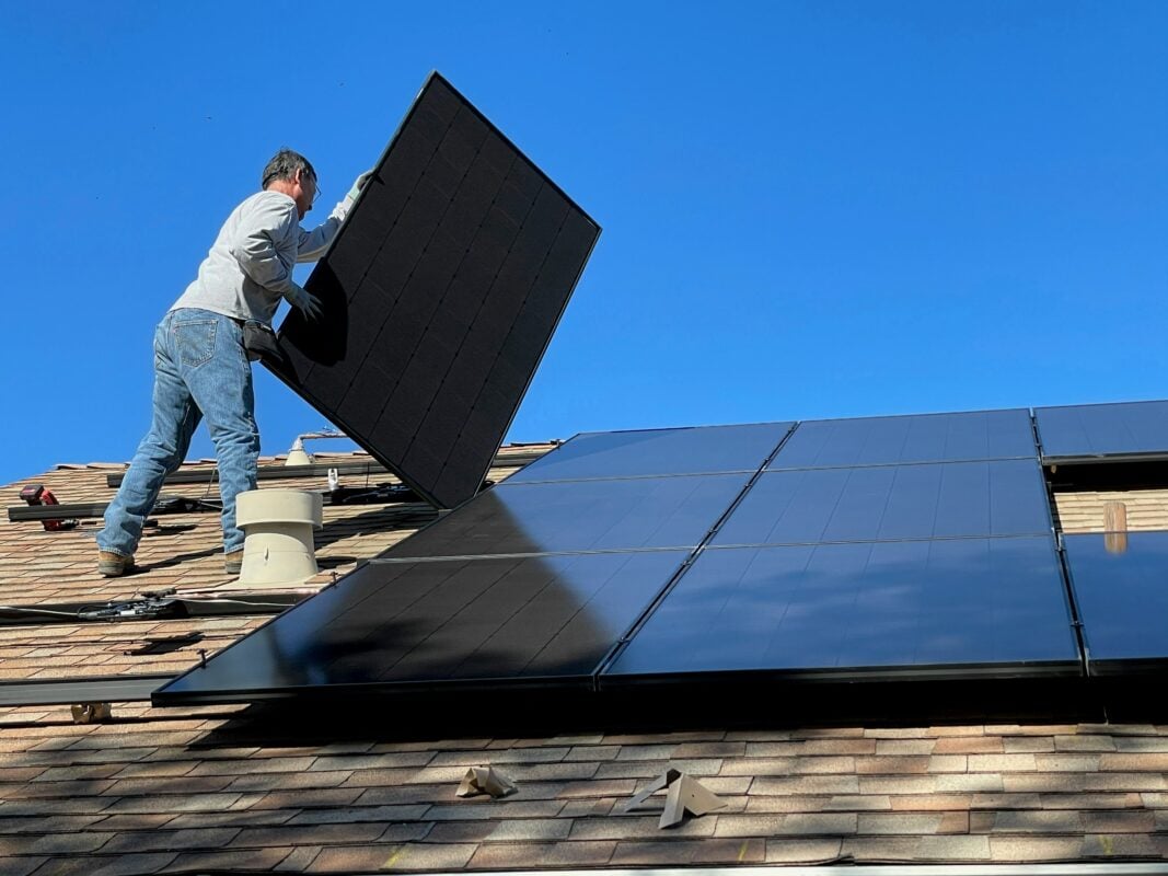 Aerial view of solar panels in California with a clear blue sky, symbolizing renewable energy leadership.