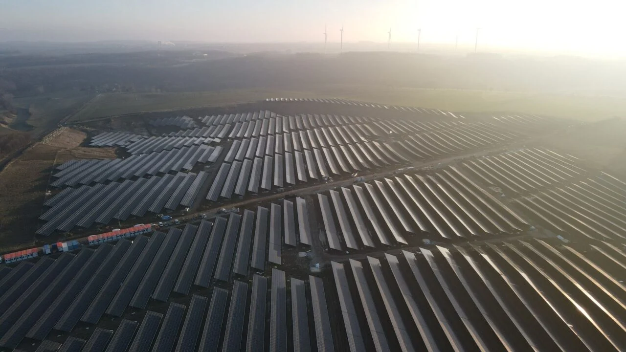 A technician inspecting a large-scale solar panel installation on a commercial rooftop in Europe.