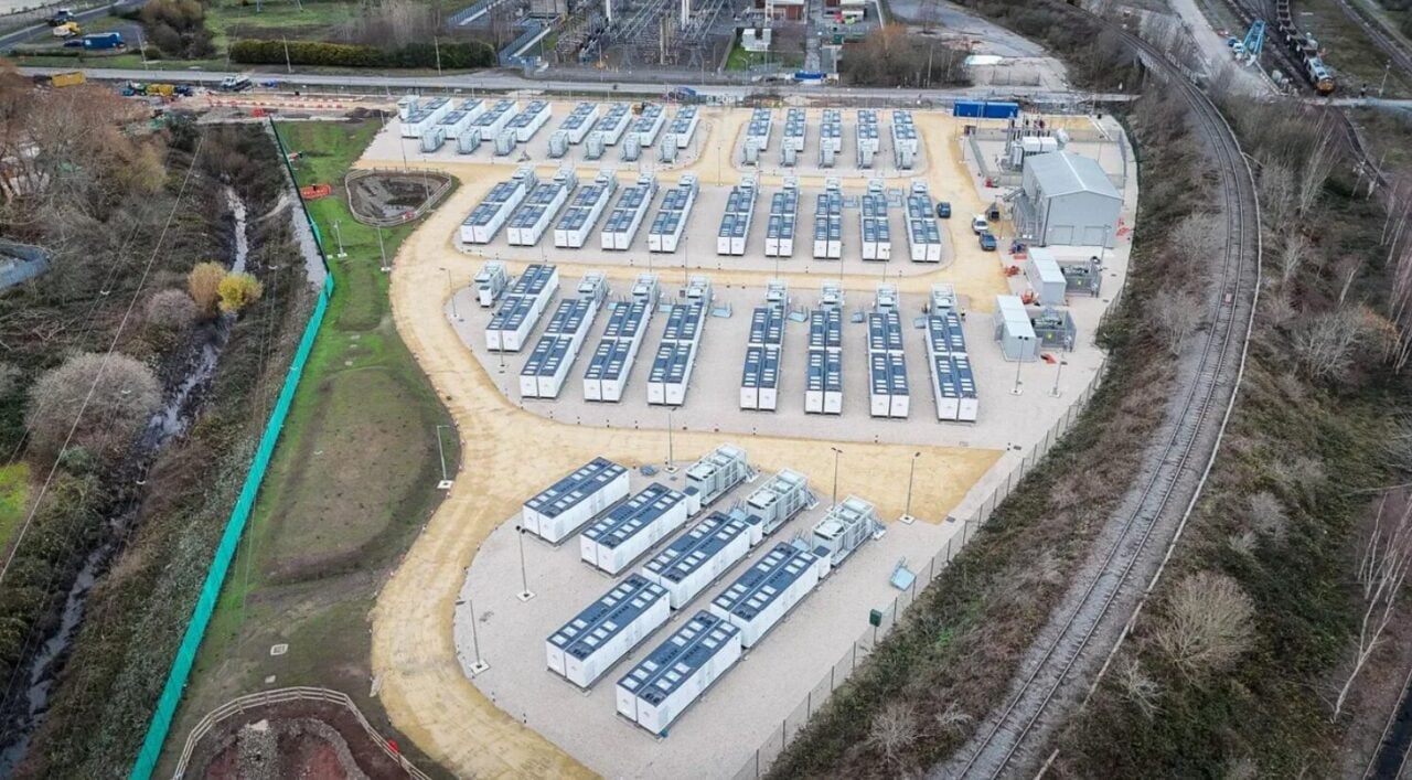 Large-scale lithium-ion battery energy storage system containers installed at a UK solar project site.