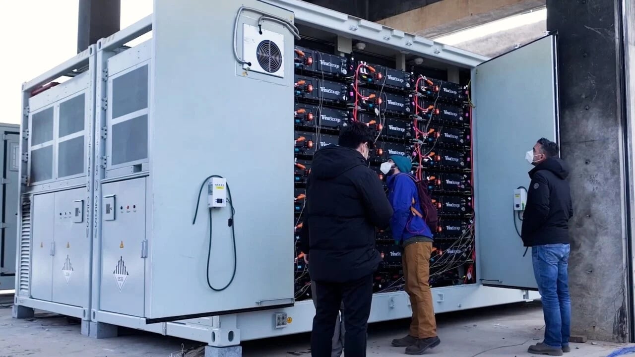 A technician inspecting a modular residential energy storage system in a modern European home.