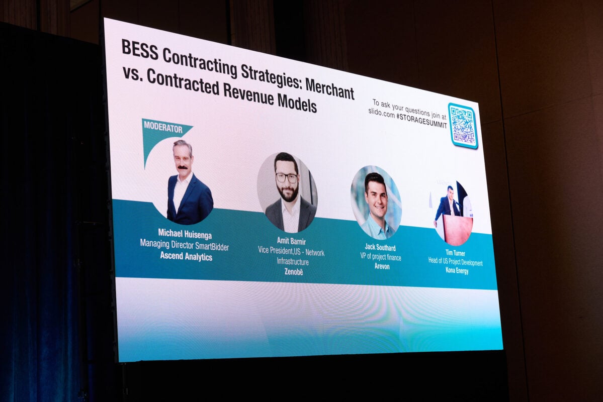 Solar panels and battery storage units at a large-scale renewable energy installation site.