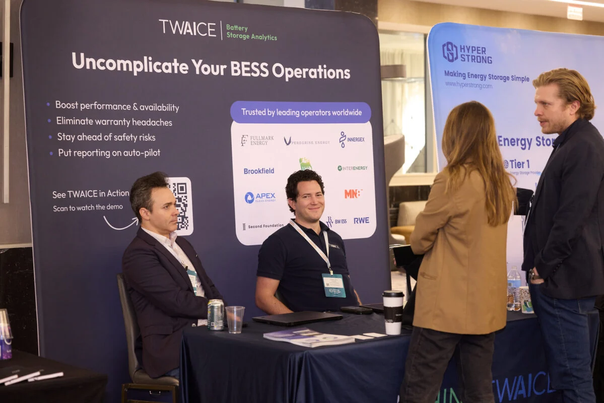 A technician using a digital tablet to monitor BESS performance data in a control room