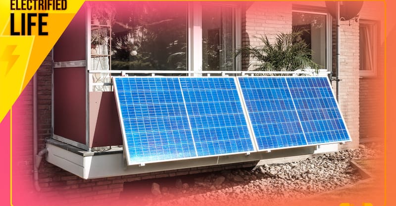 A small solar panel mounted on a residential balcony railing overlooking a city