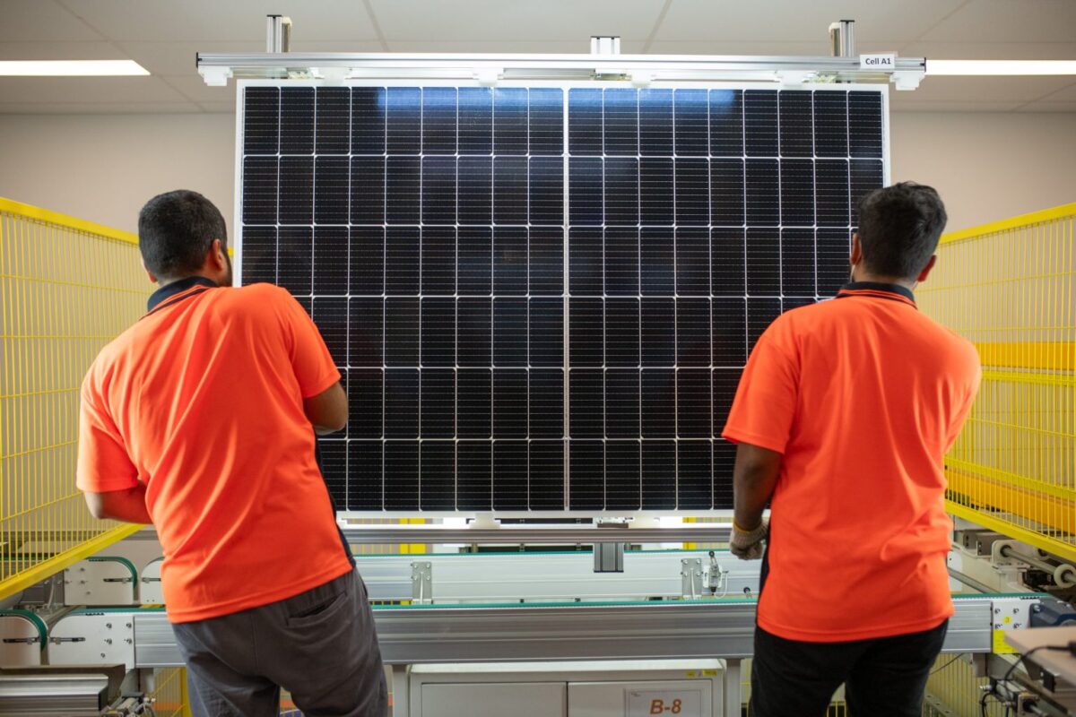 High-tech automated solar module assembly line with robotic arms in a modern factory setting.