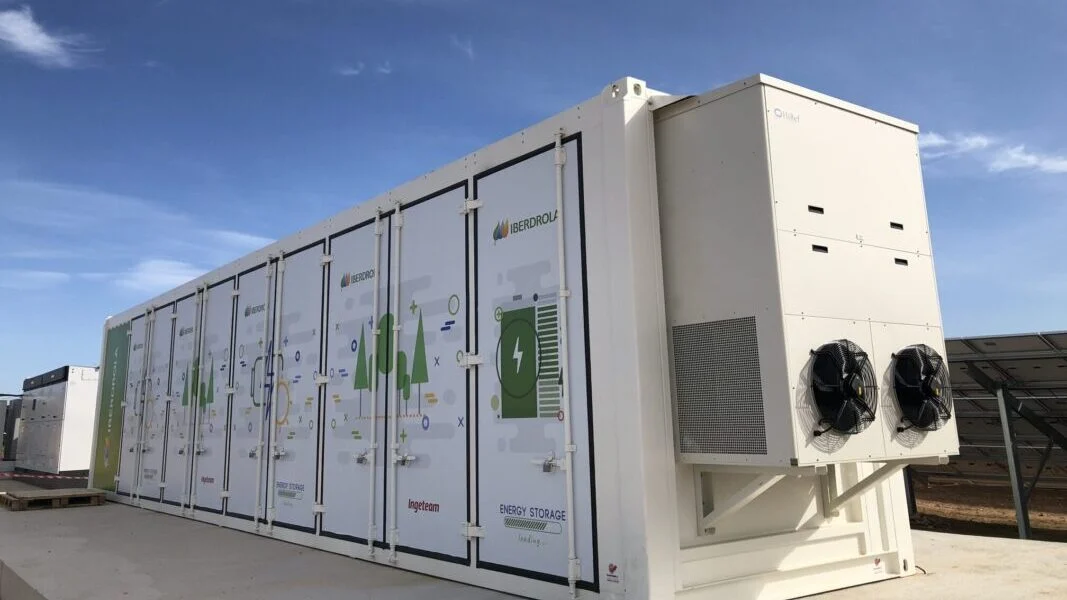 Large scale lithium-ion battery containers arranged in a grid at a utility-scale power plant.