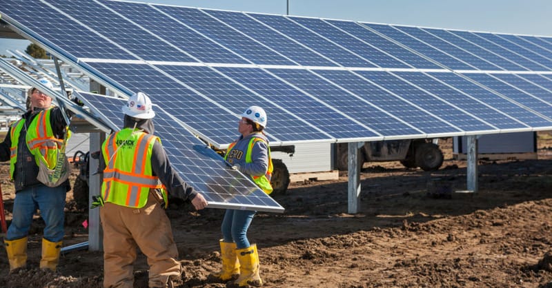 A solar project construction site with heavy machinery sitting idle due to permitting delays.