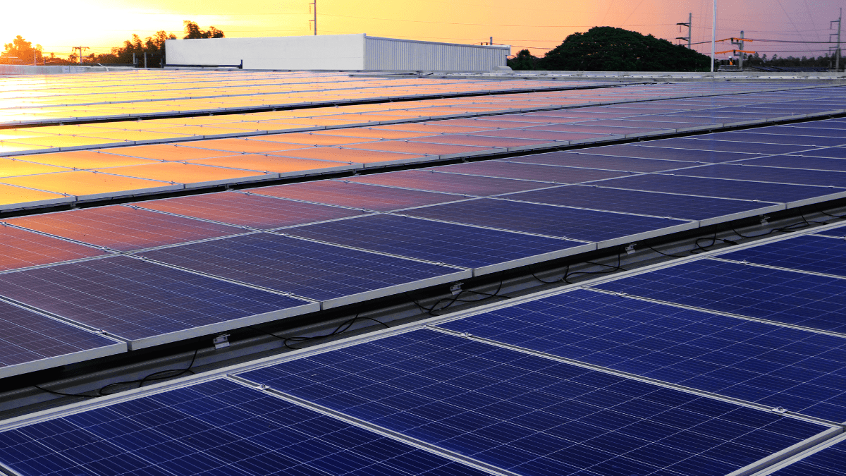 A generic solar installation on a roof with mountains in the background