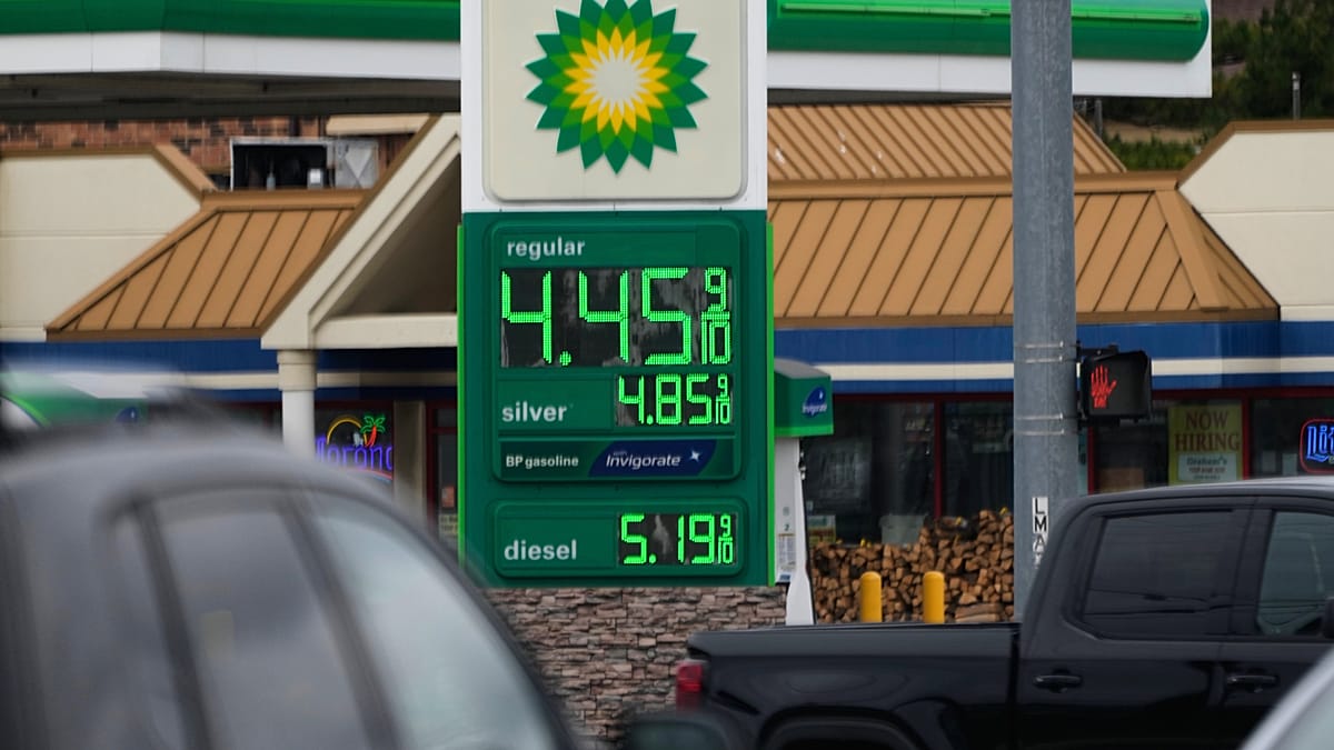A solar farm in rural Germany with wind turbines in the background during a sunset