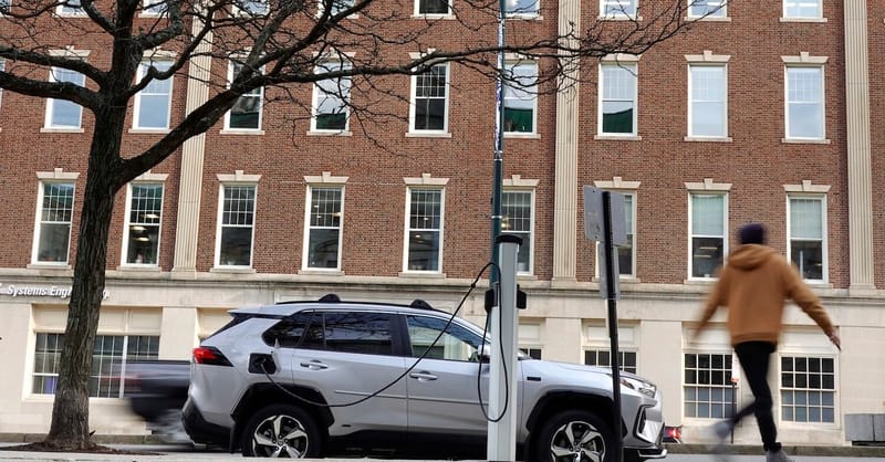 A row of electric vehicle charging stations installed in a public parking lot.