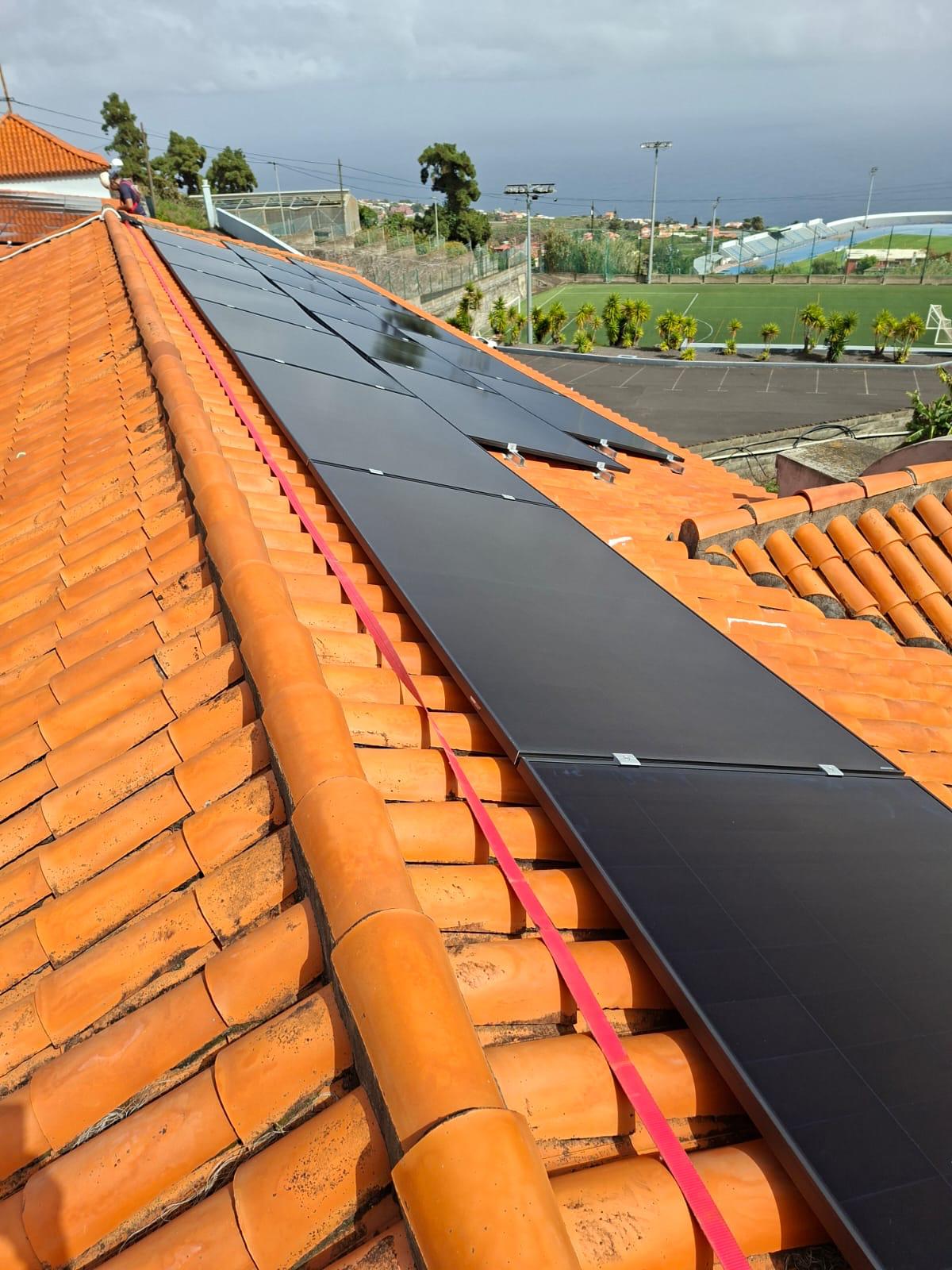 A 25kW solar photovoltaic system installed on a tiled roof of a laboratory building.