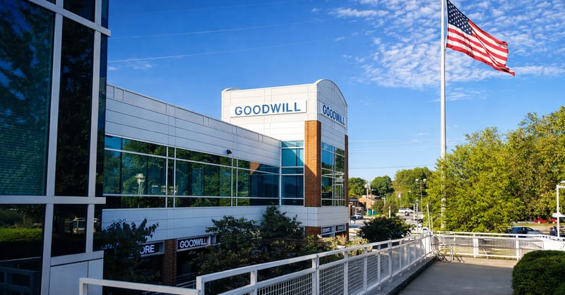 A large solar panel array installed on the rooftop of a modern food bank facility.
